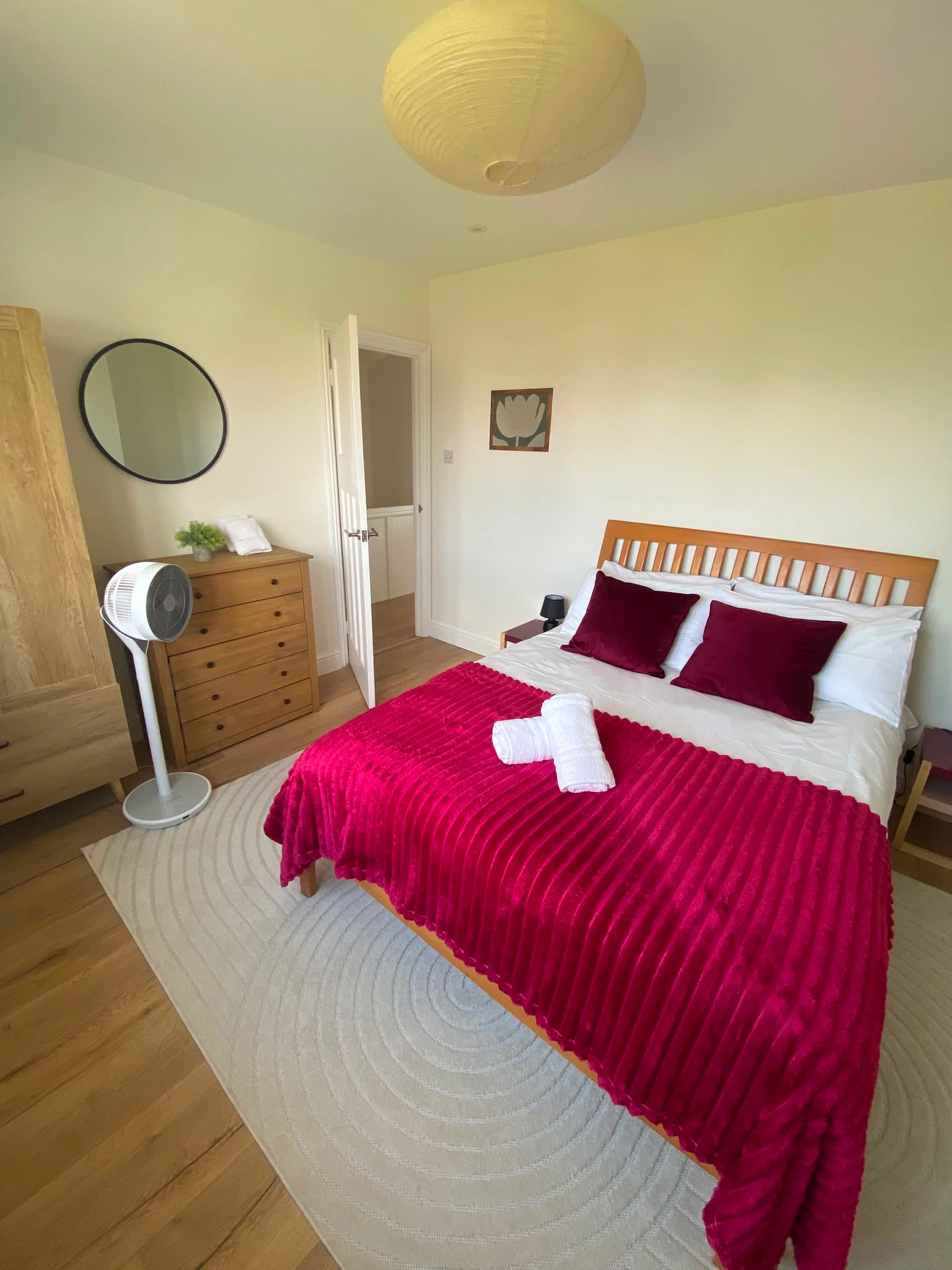 Clean and prepared double bedroom with red bedding